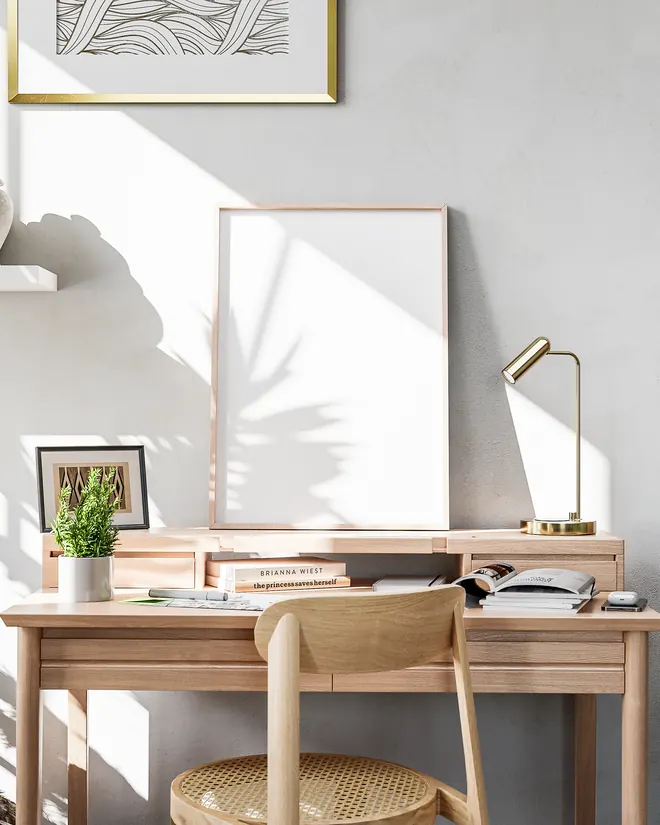 Personalisiertes Poster im Eichenrahmen über einem Schreibtisch, Monstera und Trockenblumen